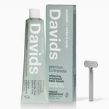 David's premium toothpaste with packaging and a dental tool on a white background