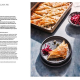 A printed recipe page featuring the title 'SAVOUHY BAKLAVA PIE' at the top left, with a large food photograph on the right showing layered golden-brown pastry, a baking tray, and a small bowl of red cabbage. The left side contains the recipe text.