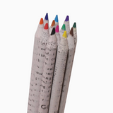 A set of six colored pencils wrapped in a printed paper sleeve, standing upright against a plain white background.
