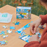Person playing with a puzzle on a table next to a 'Good Green Bag' product and a mini puzzle box.