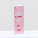 Pink box of 'Besito' tinted balm by Lovewild on a white background