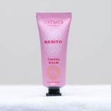 Pink tube of 'Besito' tinted balm on a light gray background